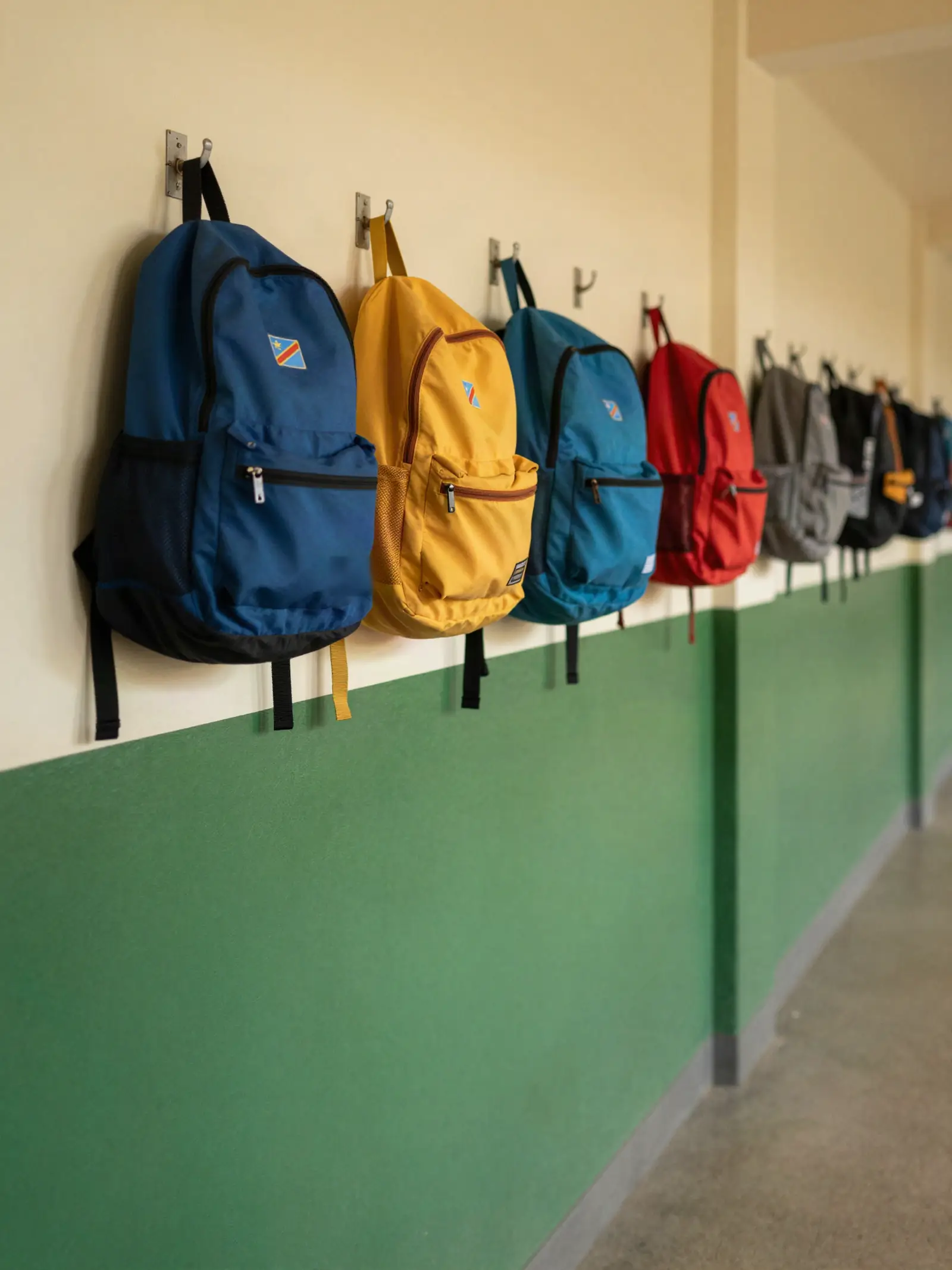 Des sacs d'école accrochés dans un couloir