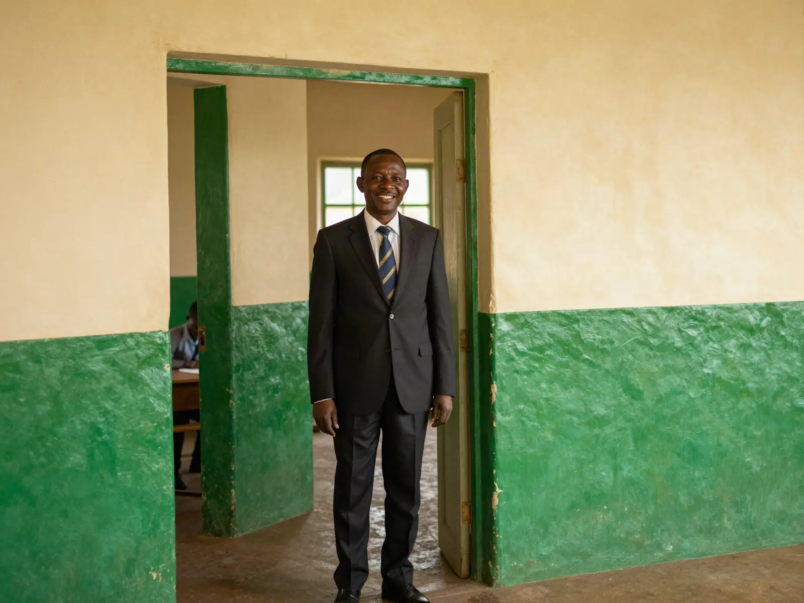 Un directeur d'école dans l'encadrement d'une porte de classe